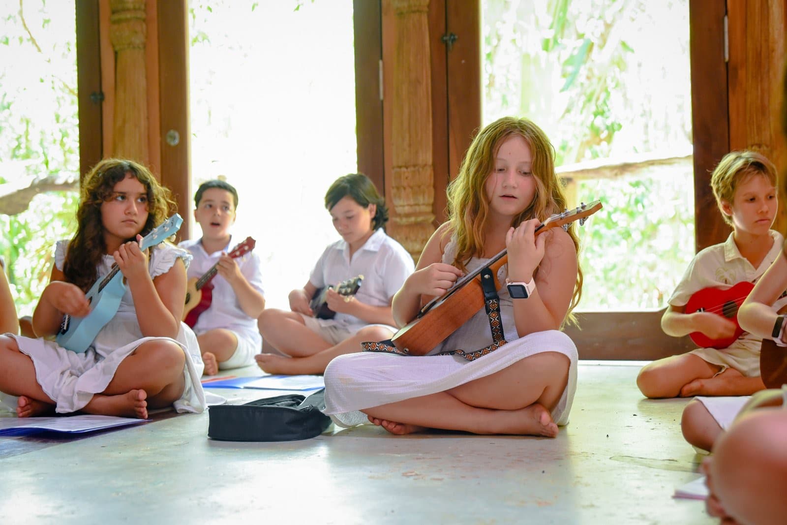 Niña tocando el ukelele en la escuela en la selva