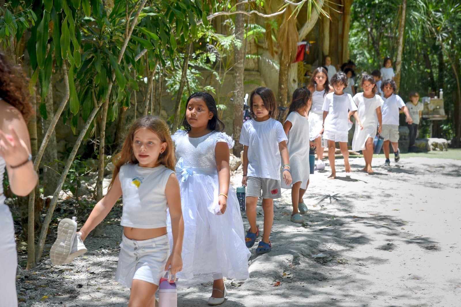 Niños caminando en fila por un sendero de la selva