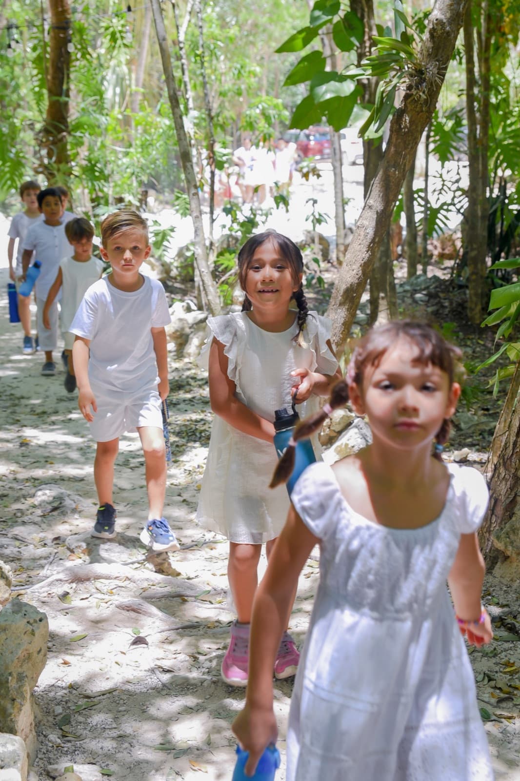 Niñas y niños explorando un sendero entre árboles